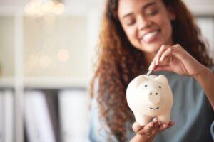 Woman putting a coin to her piggy bank